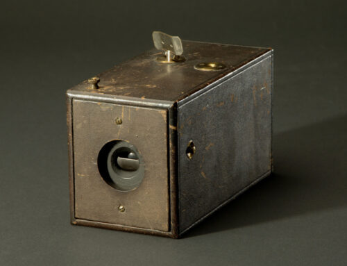 The First Kodak Camera Resting On A Dark Surface, Encompassing The History Of Photography.