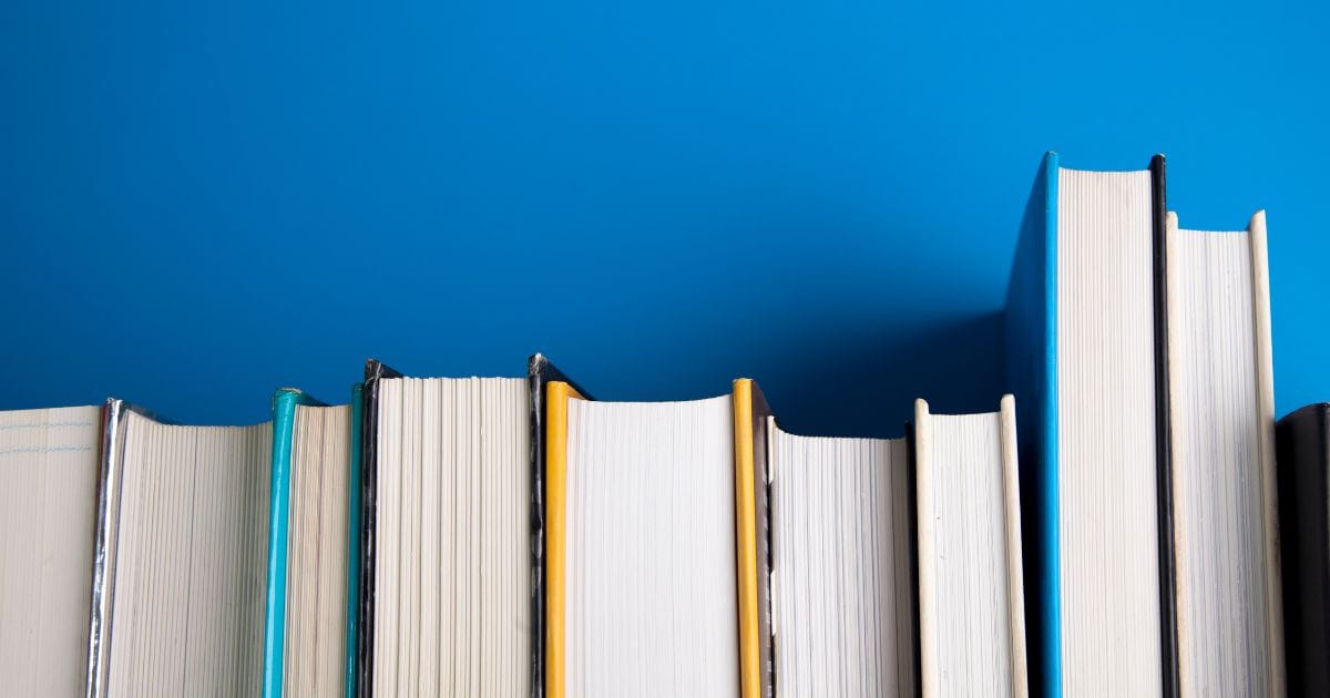 A Stack Of Books On A Blue Background, Perfect For Photography Beginners.