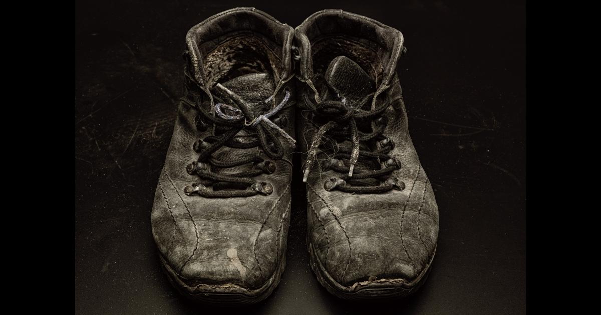 Photography: Worn Out Boots On A Black Background.