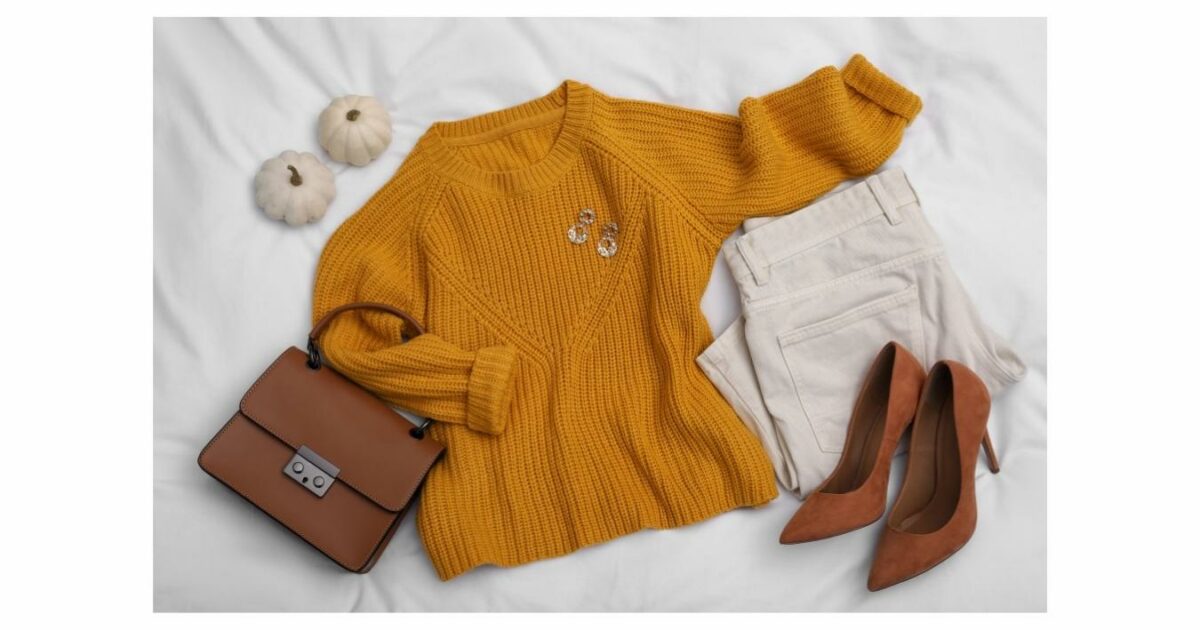 A Yellow Sweater, White Pants And A Purse On A Bed, Showcasing An Ideal Outfit For A Photoshoot.
