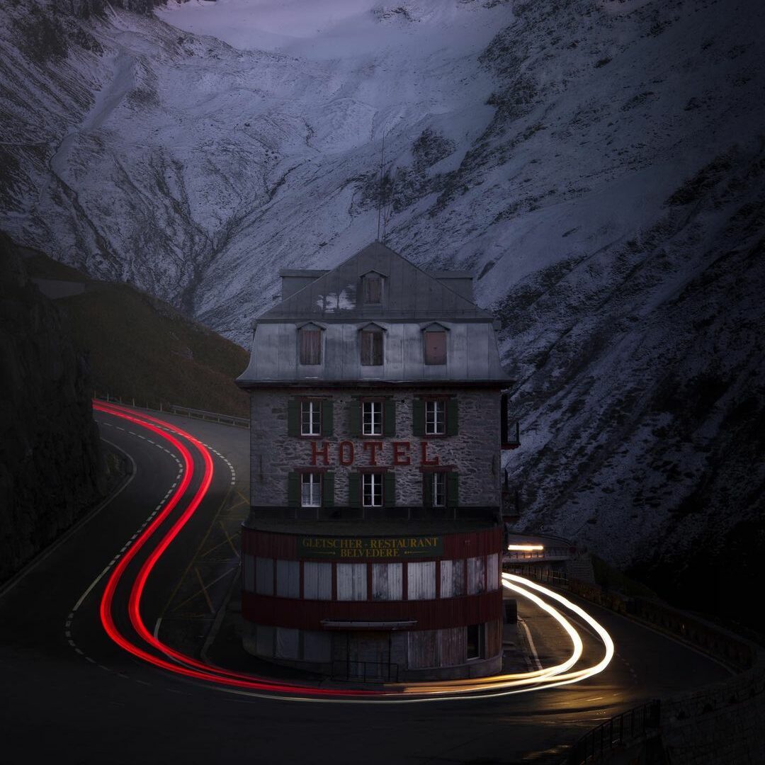 A Photograph Capturing The Effect Of Long Exposure On A Mountain Road, With A Building In The Background.