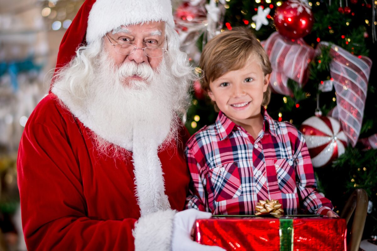 Santa Claus Posing With A Young Boy During A Festive Photoshoot.
