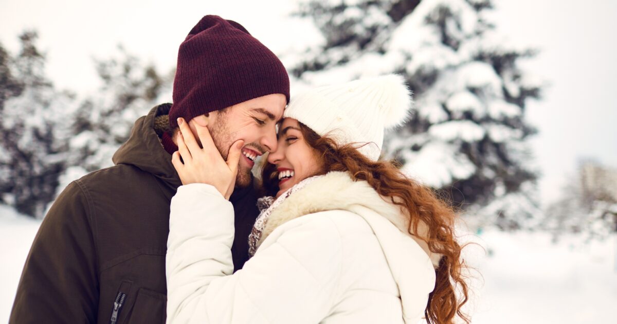 A Man And Woman Embracing In The Snow, Capturing The Warmth And Love Of Holiday Family Photos.