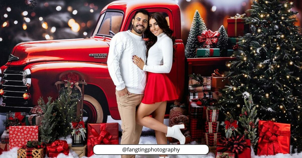 A Couple Posing In Front Of A Red Truck With Christmas Decorations.
