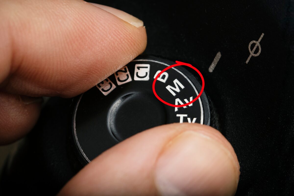 A Person Is Holding A Button In Manual Mode With A Red Circle On It.