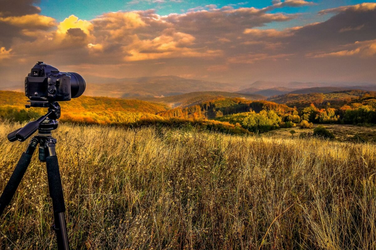 A Tripod With A Camera Capturing Nature Photography In The Middle Of A Field.