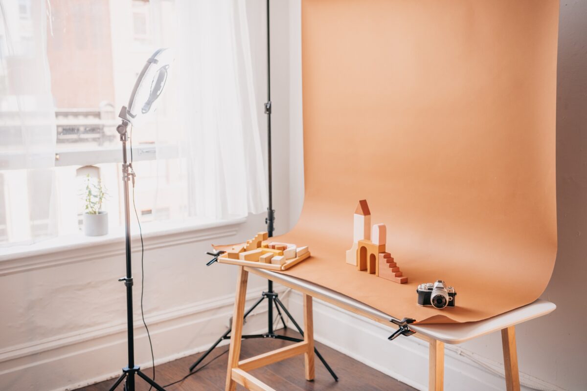 A Photography Background Featuring A Wooden Table And A Light Stand.