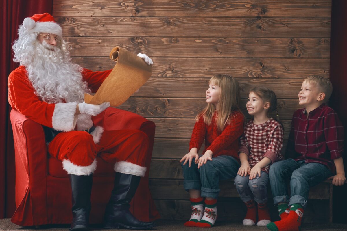 Santa Claus Is Delightedly Reading A Letter To Children During His Heartwarming Santa Mini Sessions.