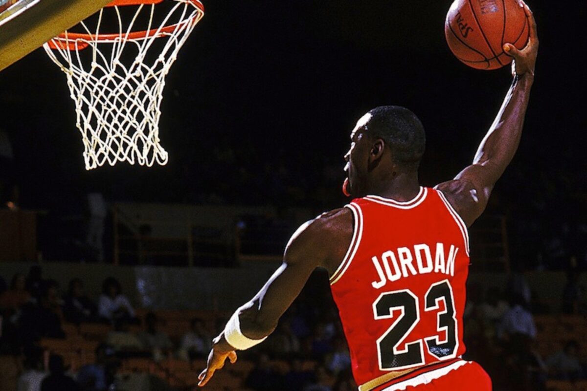 Michael Jordan Showcases His Fierce Athleticism By Executing A Spectacular Basketball Dunk During A Game.