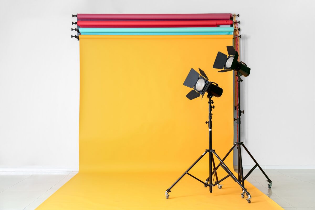 A Set Of Lights And A Photography Backdrop In Front Of A Yellow Background.