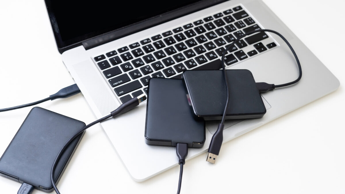 A Laptop Equipped With Two External Hard Drives For Storing And Backing Up Photos.