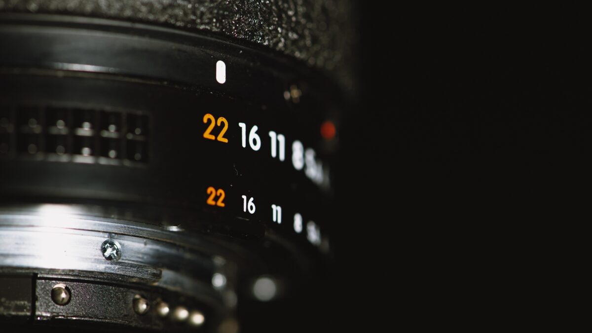 A Close Up Of A Camera Lens, Showing The Intricate Details Of Its Design.