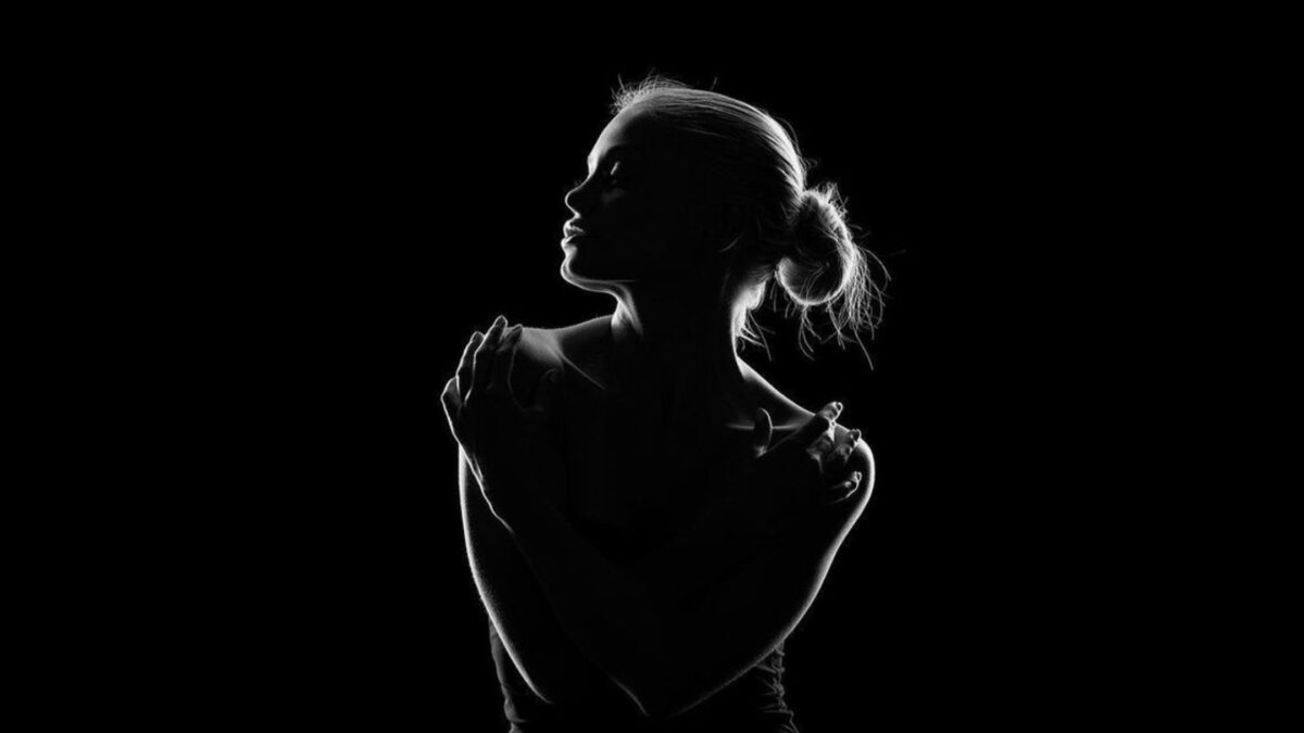 A Shadow Photography Of A Woman On A Black Background.