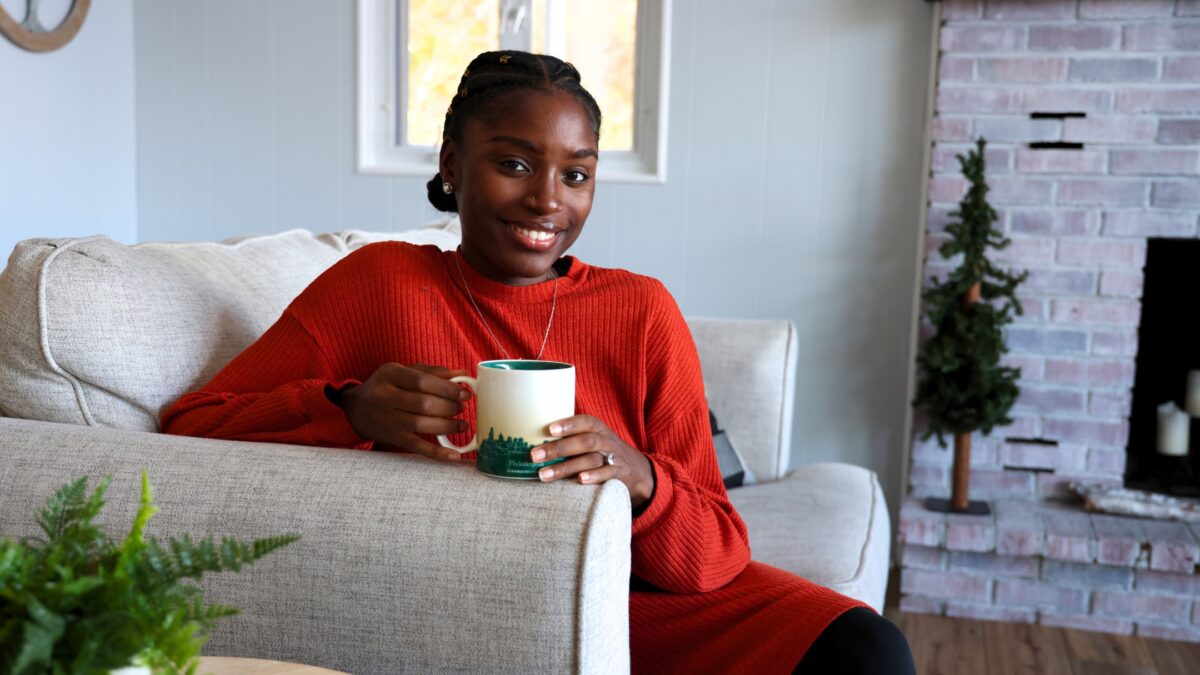 A Woman Sitting On A Couch Holding A Coffee Mug, Showcasing One Of The Props To Bring To A Photoshoot.