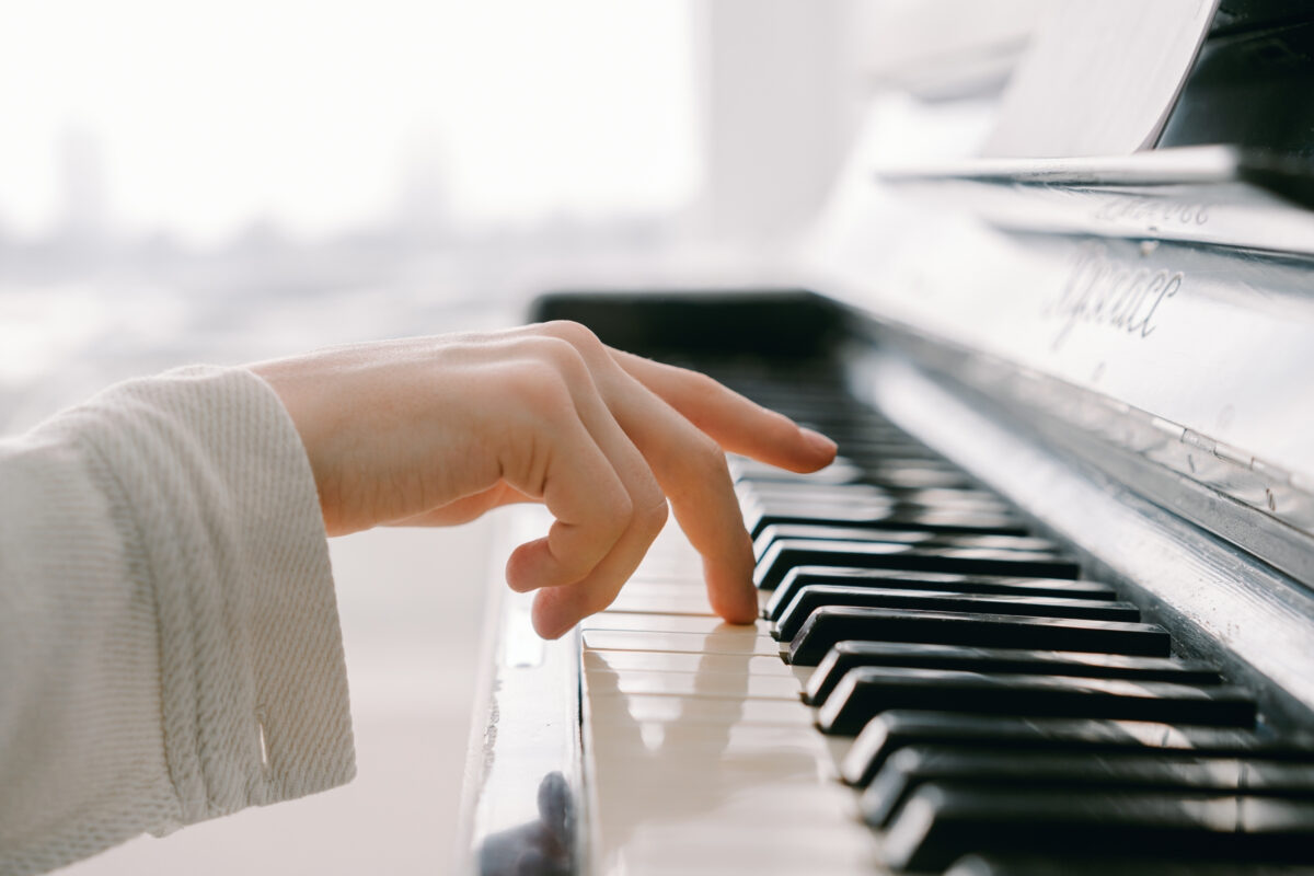 A Woman'S Hand Is Meticulously Playing A Piano, Capturing A Stunning Composition In Photography.