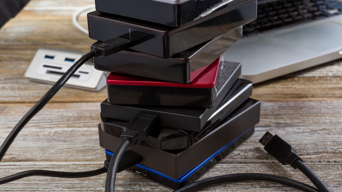 A Stack Of Usb Chargers Next To A Laptop, Ready To Store And Backup Photos.