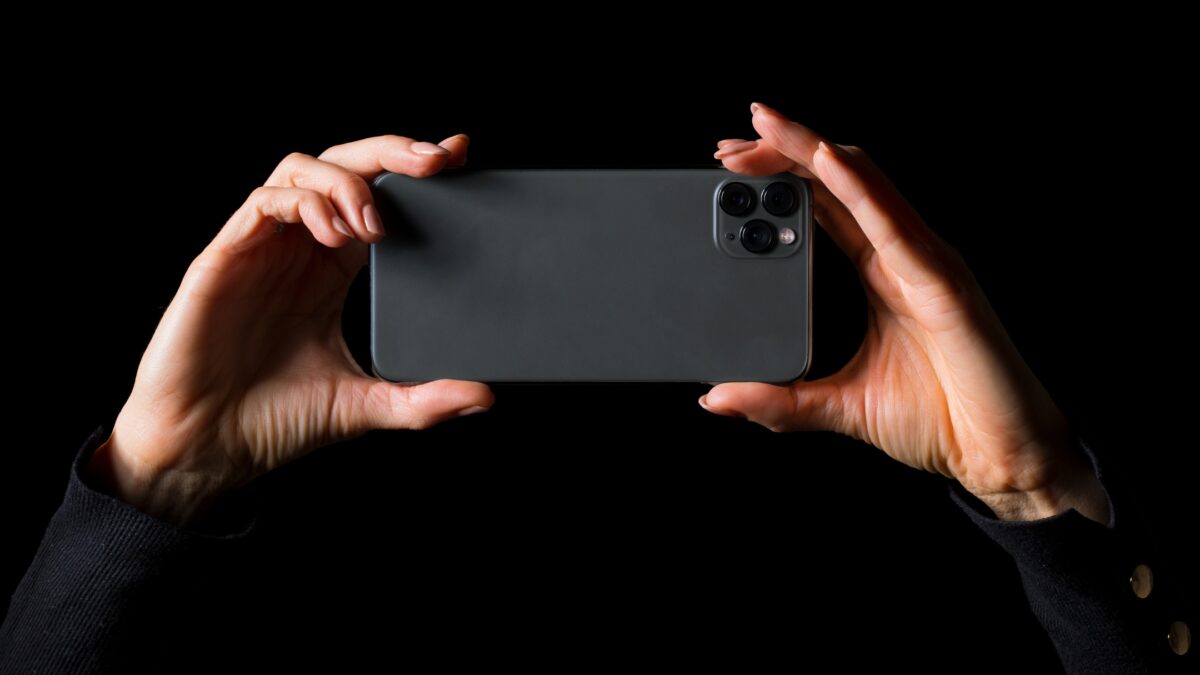 A Woman'S Hands Are Holding A Black Iphone 11 Pro To Capture Photos With Her Smartphone.
