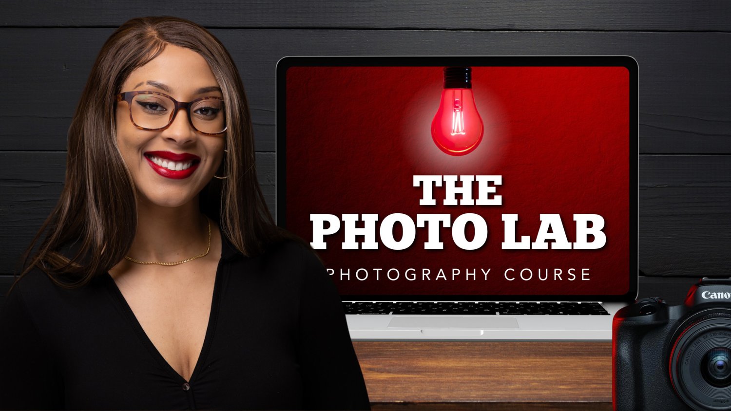 Smiling Woman With Glasses Facing The Camera, Standing In Front Of A Laptop Displaying &Quot;The Photo Lab Video Course&Quot; And A Red Light Bulb Image; Camera Partially Visible In The Foreground.
